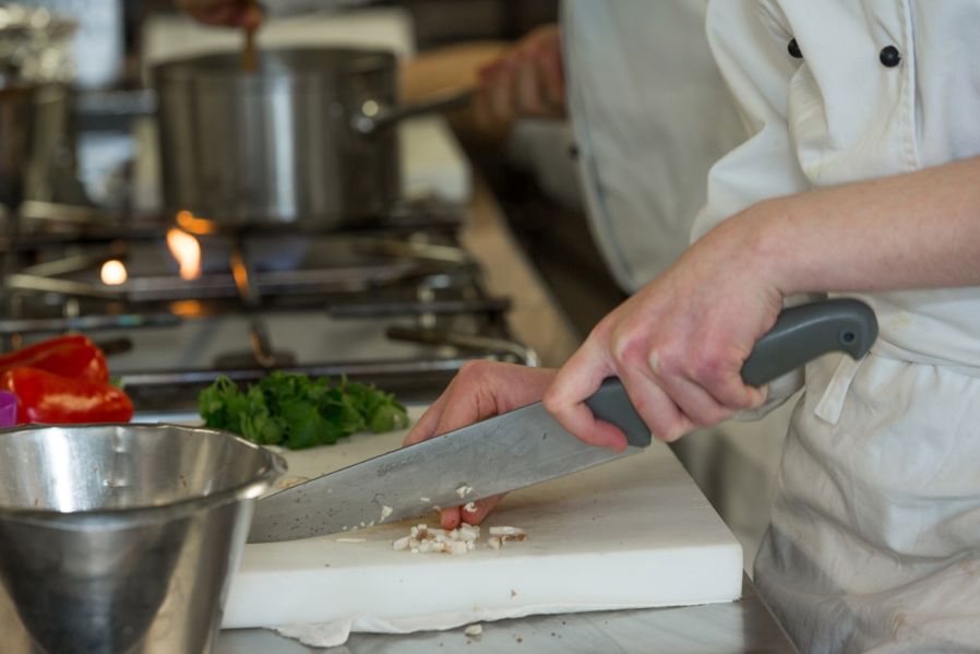 Kokk skjærer grønnsaker